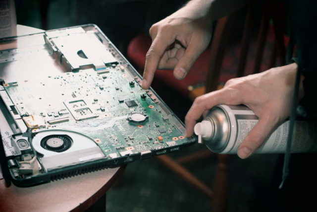 Using compressed air to clean a laptop interior